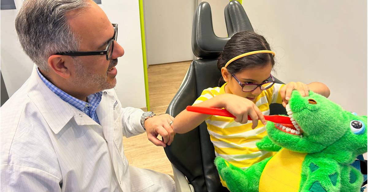 A-child-plays-with-a-toy-dinosaur-in-a-dental-office-while-an-adult-watches