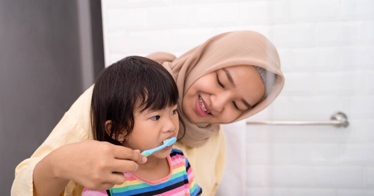 Adult-and-child-in-a-bathroom-adult-is-wearing-a-hijab-and-holding-a-brush