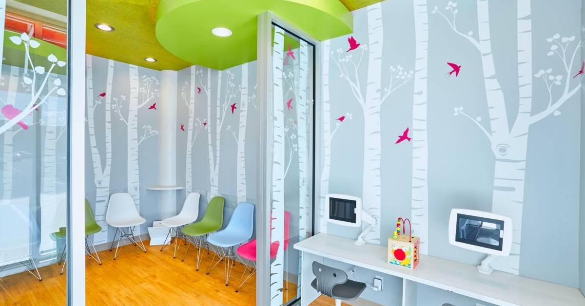 Colorful-childrens-clinic-waiting-room-with-forest-themed-walls-and-modern-furniture