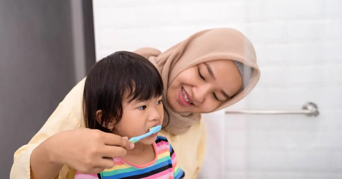 Adult-and-child-in-a-bathroom-adult-is-wearing-a-hijab-and-holding-a-brush