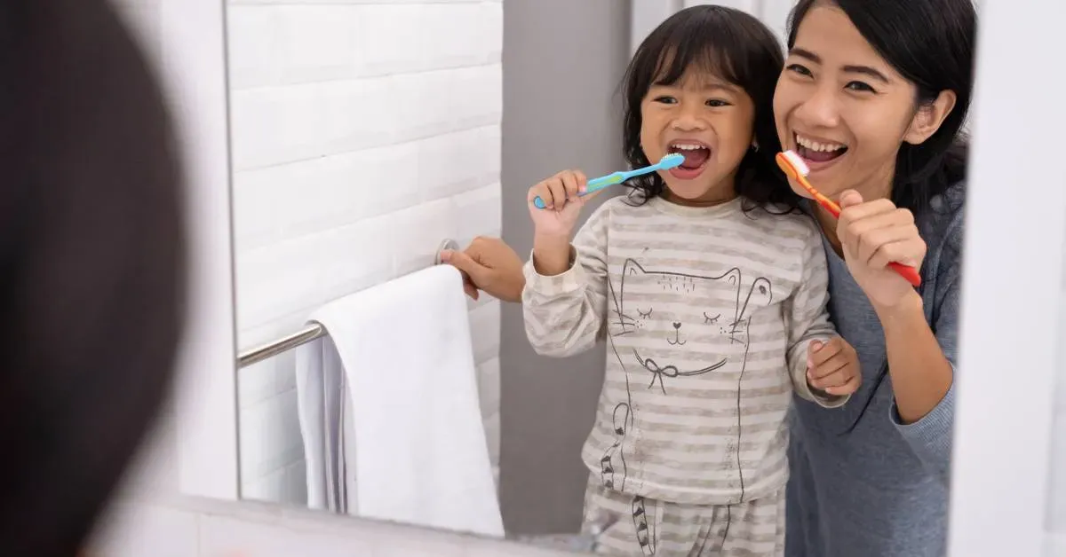 Two-people-brushing-teeth-in-front-of-a-bathroom-mirror
